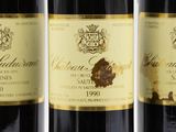 three bottles of wine are lined up on a white surface
