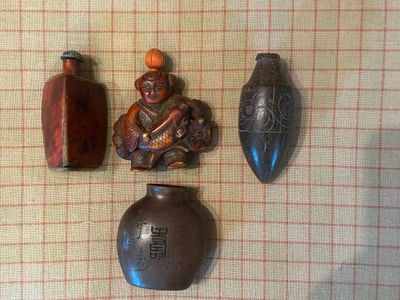 trois vases posés sur une table, avec une petite figurine à côté