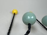 three balls that are attached to a black rope