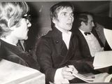 black and white photograph of a man in a suit and tie sitting next to another man