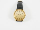 une photo d'une montre-bracelet plaquée or avec un bracelet en cuir noir