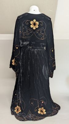 an image of a black dress with gold flowers on a mannequin