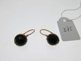 a pair of black glass earrings on a white background