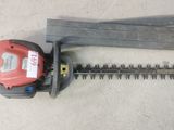 a close up of a hedger and a saw on the ground