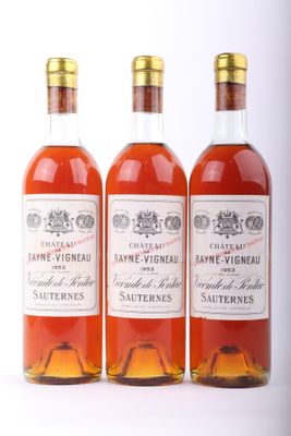 trois bouteilles de vin posées les unes à côté des autres sur une surface blanche
