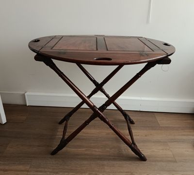a small wooden table with two crossed legs on it