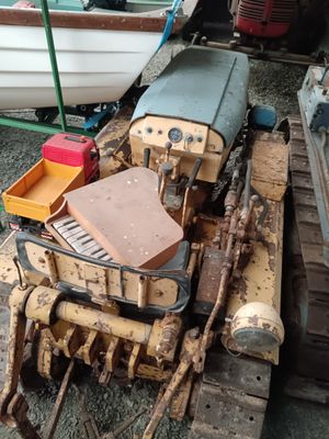 a small toy train on the ground next to a small boat