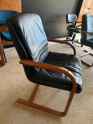 un fauteuil en cuir noir et un fauteuil bleu dans une pièce