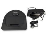 a black robot that is sitting next to a charger