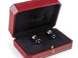 pair of cufflinks in a red leather case