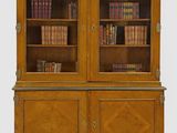 une grande bibliothèque en bois à deux portes, dont les étagères sont remplies de livres