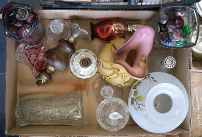 une boîte remplie d'objets en verre de toutes sortes posée par terre