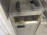 a picture of a commercial kitchen with two deep fryers