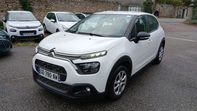 une Citroën blanche garée sur un parking à côté d'autres voitures