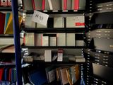 a book shelf full of books and binders in a room