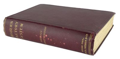 un vieux livre brun posé sur une surface blanche
