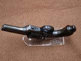 a small black object on a clear stand on a brown surface