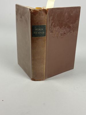 a book with a brown cover sitting on top of a white table
