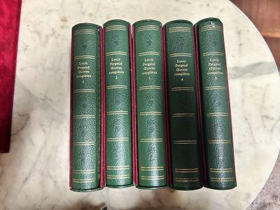four green books are sitting on a marble table