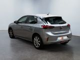 the back end of a silver car in a white room