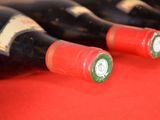 several bottles of wine are lined up on a red table