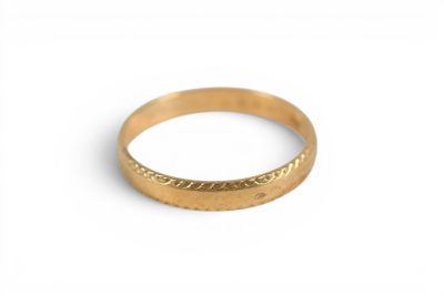 gros plan d'une bague en or sur une surface blanche