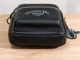 the small black bag is sitting on a wooden table