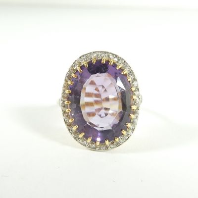 une bague ovale sertie d'un améthorate et de diamants sur un fond blanc