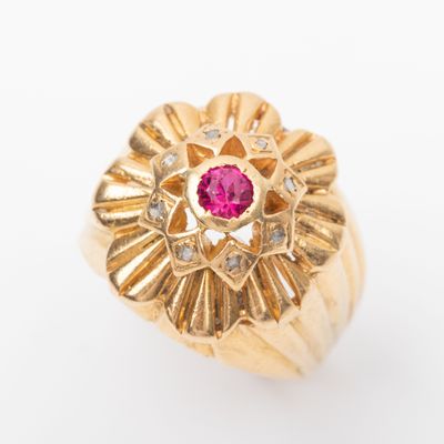 une image d'une bague en or avec une pierre rose au centre