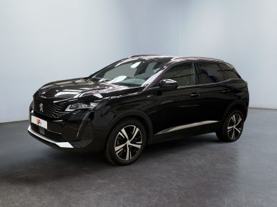 Le SUV noir est garé dans une pièce au sol gris.