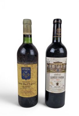 two bottles of wine sitting next to each other on a white surface