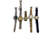 three watches are lined up in a row on a white surface