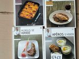 four cookbooks of various types of food are on a cardboard box