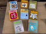 several children ' s books are sitting on a table in front of a chair