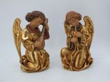 pair of gold angel figurines sitting on a white surface