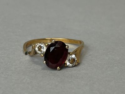 Bague en or 750 °/°° ornée en son centre d'une pierre rouge épaulée de - Photo 1