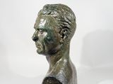 bronze bust of a man on a white surface with a white background