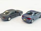 two toy cars sitting next to each other on a white surface