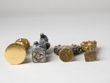 three different types of cuff rings and a coin on a white surface