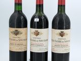 three bottles of red wine sit side by side on a white surface