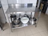 a stainless steel table with pots and pans on it