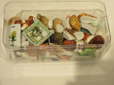 a plastic container filled with assorted seashells on a table