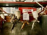 a bunch of airbrushes hanging on a wall