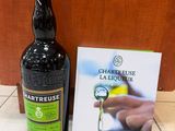 une bouteille d'alcool posée à côté d'un livre, par terre