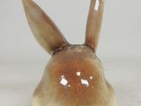 a small ceramic rabbit sitting on a white surface