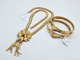 two gold bracelets and a necklace with a lion head on it