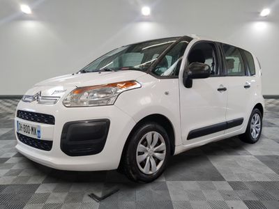 la petite camionnette blanche est garée sur un carrelage à carreaux