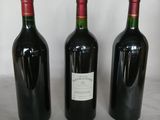three bottles of wine are lined up on a table