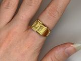a woman ' s hand with a gold ring on it