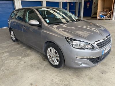 une voiture grise garée dans un garage dont la porte est bleue